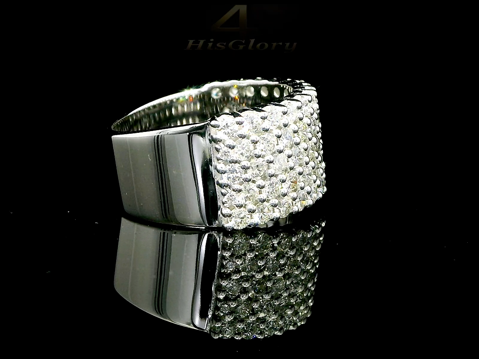 Close-up image of a white gold ring encrusted with multiple small diamonds, reflecting light on a black surface. The ring features a pattern of closely set diamonds creating a sparkling effect.