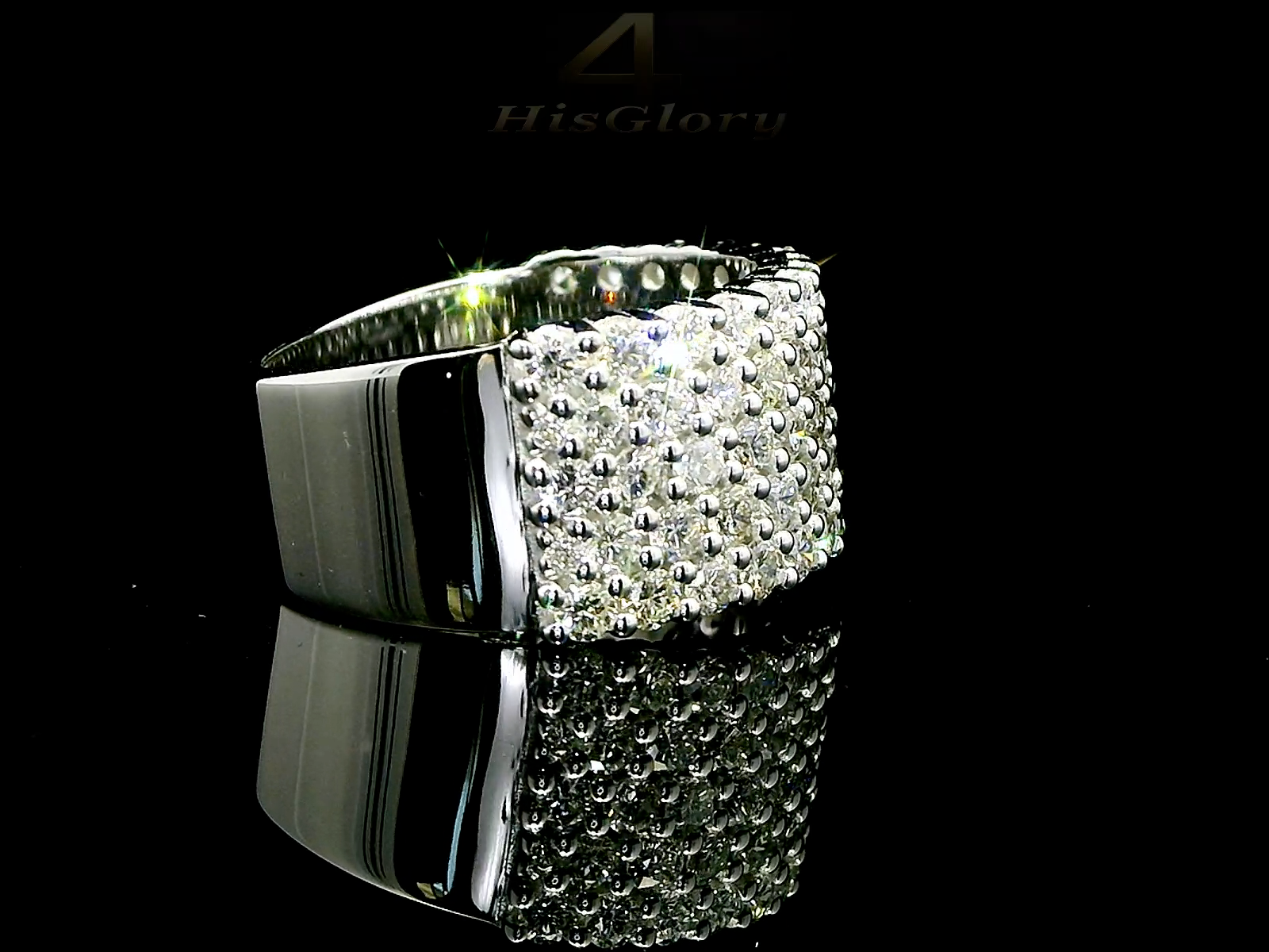 Close-up image of a white gold ring encrusted with multiple small diamonds, reflecting light on a black surface. The ring features a pattern of closely set diamonds creating a sparkling effect.
