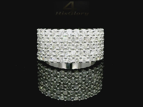 Close-up image of a white gold ring encrusted with multiple small diamonds, reflecting light on a black surface. The ring features a pattern of closely set diamonds creating a sparkling effect.